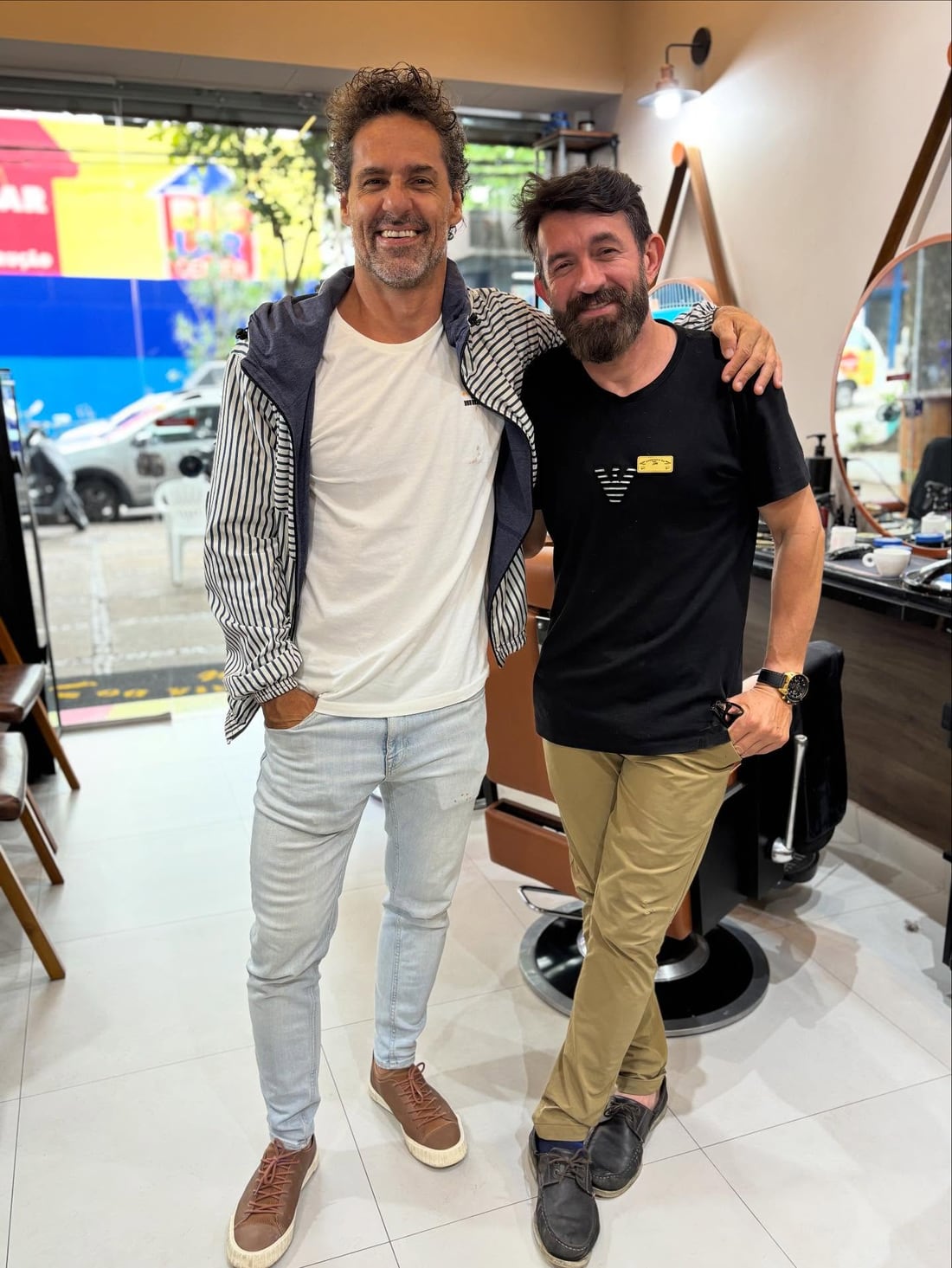 Tim, fundador da Barbearia do Tim, recebendo um cliente na porta